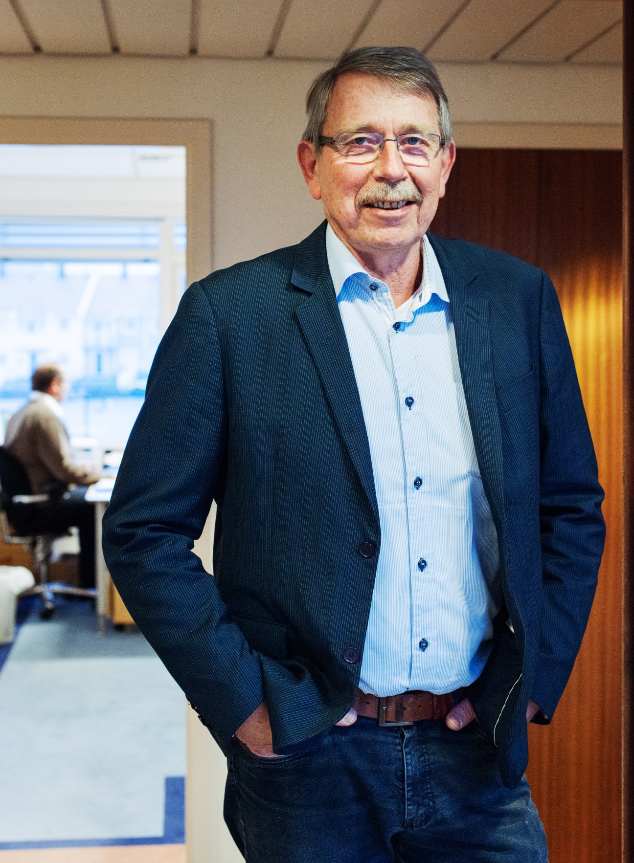 Kjell Inge Andreassen, head of OSM Ship Management, stands in an office with a harbour view behind him.
