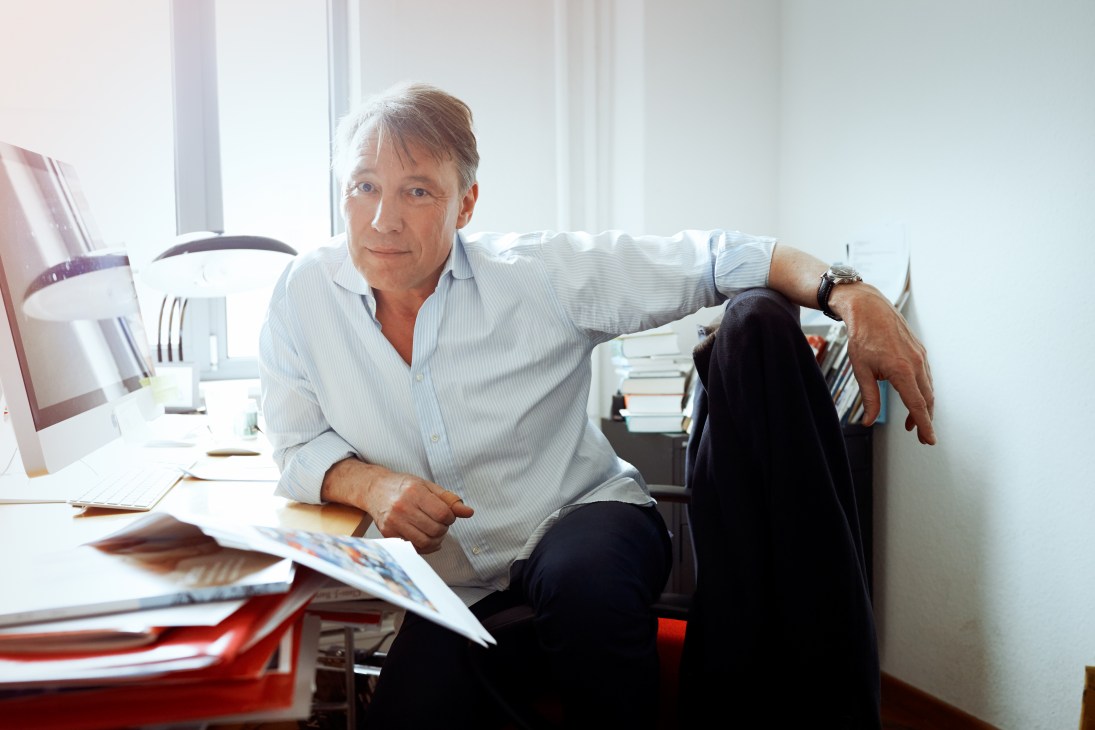 Karl Spurzem, deputy editor in chief of Mare magazine, sits at his desk in a light-filled office surrounded by publications and books.