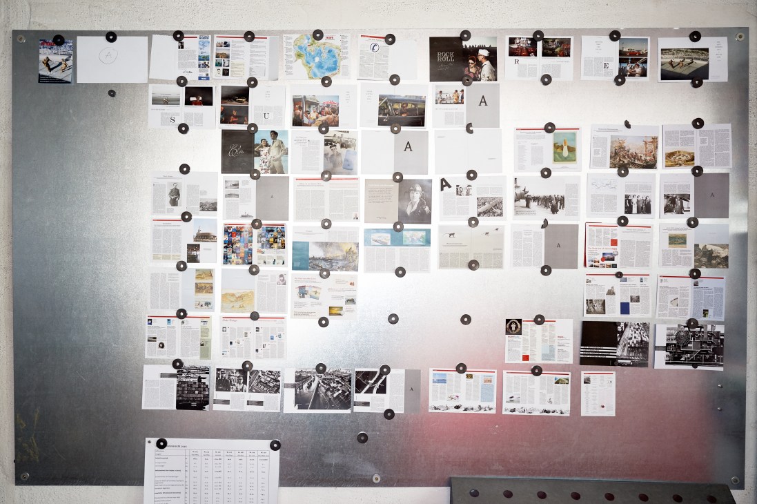 Magazine layouts and proofs pinned to a wall in the Mare editorial office.