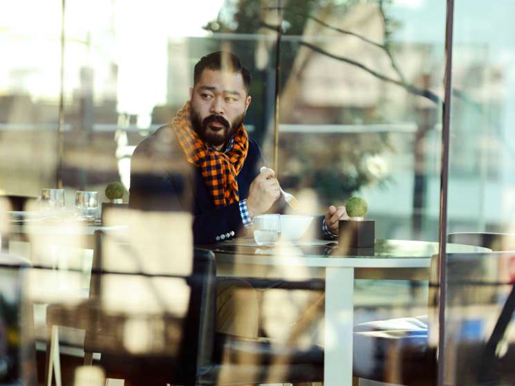 Man in Louis Vuitton jacket and scarf dining alone at Bulgari Il Café in Tokyo.