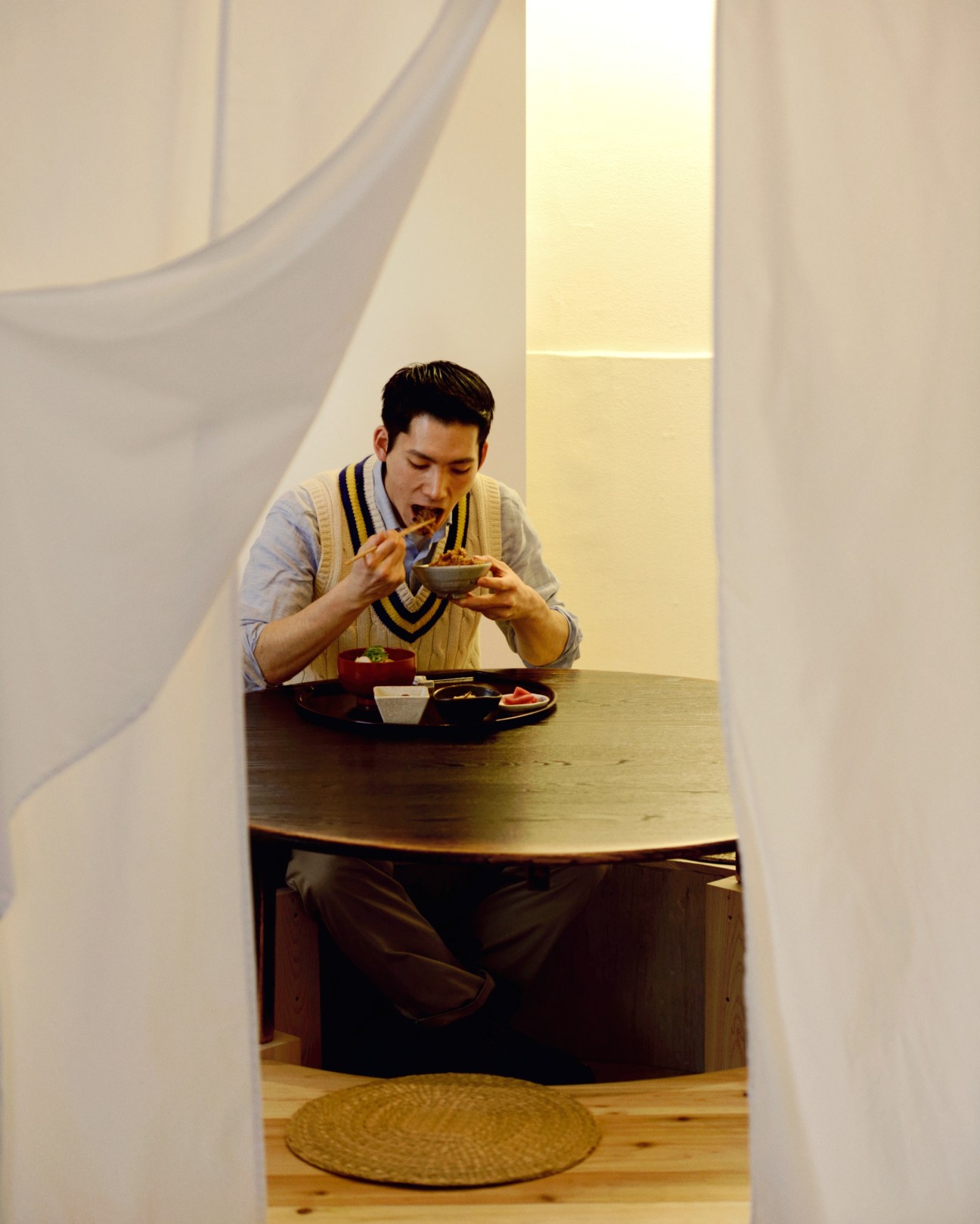 Man eating Hakozen Teishoku meal alone at a table in a minimalist Tokyo restaurant