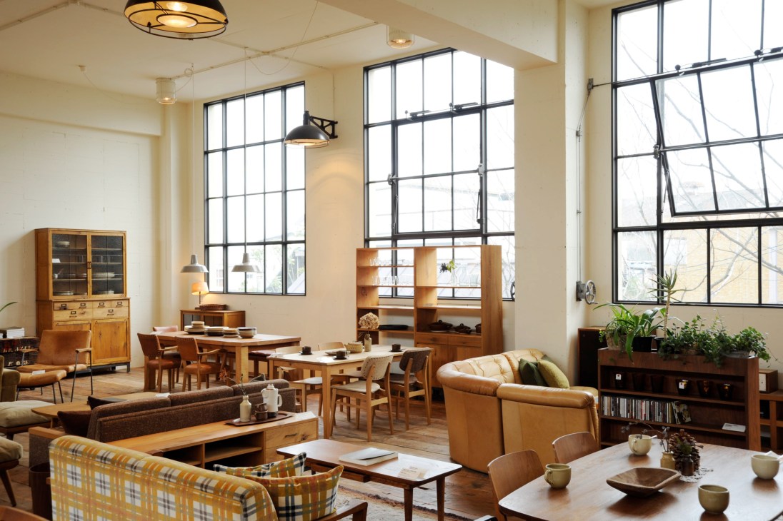 Truck's showroom displaying mid-century modern furniture including wooden cabinets, tables, chairs and leather sofas arranged as a living space.