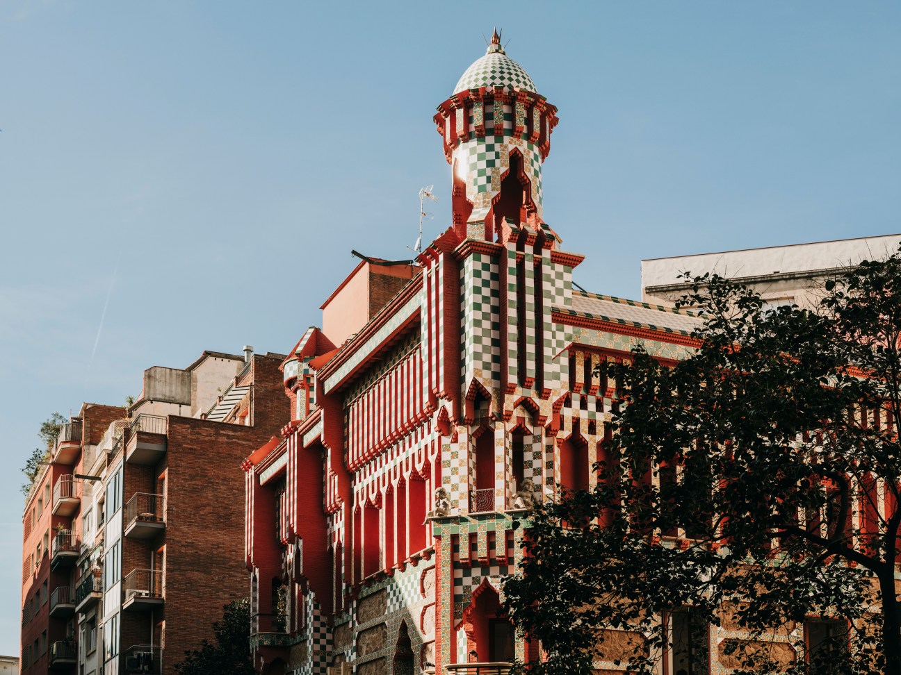 Antoni Gaudí's Casa Vicens exterior with distinctive red and green ceramic tiles and ornate tower.