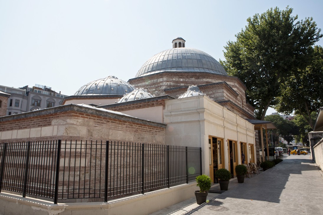 Exterior of Kilic Ali Pasa Hamami showing domed architecture with metal fence and entrance in Istanbul.