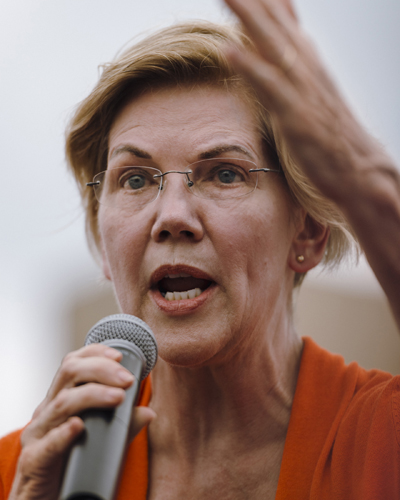 Elizabeth Warren speaking at a microphone on the Soapbox stage at Iowa State Fair