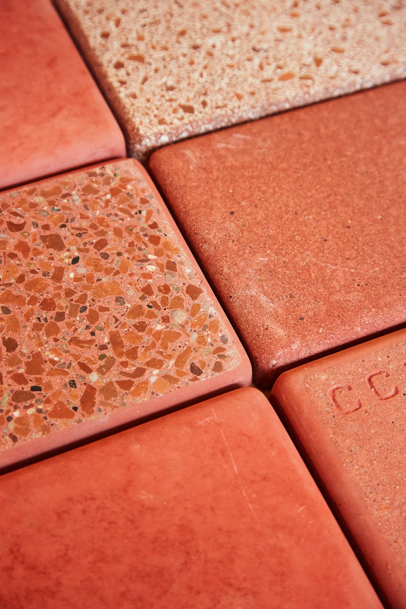 Close-up of pink concrete tiles with varying textures and finishes.