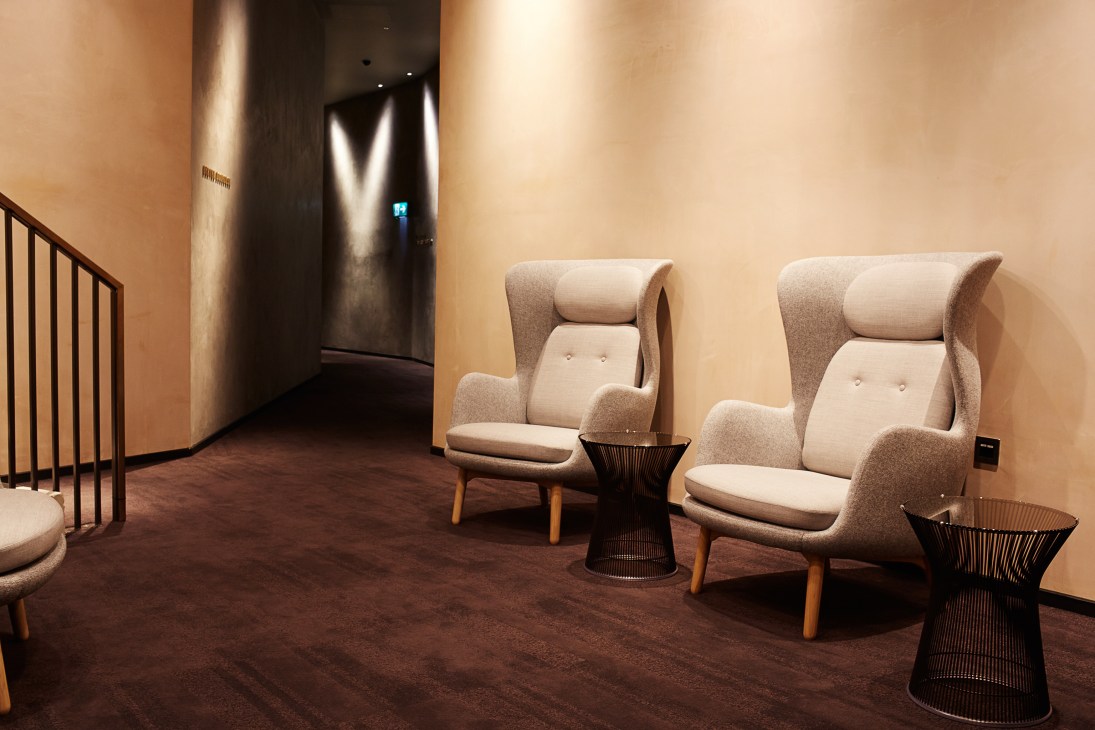 Curzon Bloomsbury lounge with Bibendum chairs, warm walls, and minimalist concrete design.