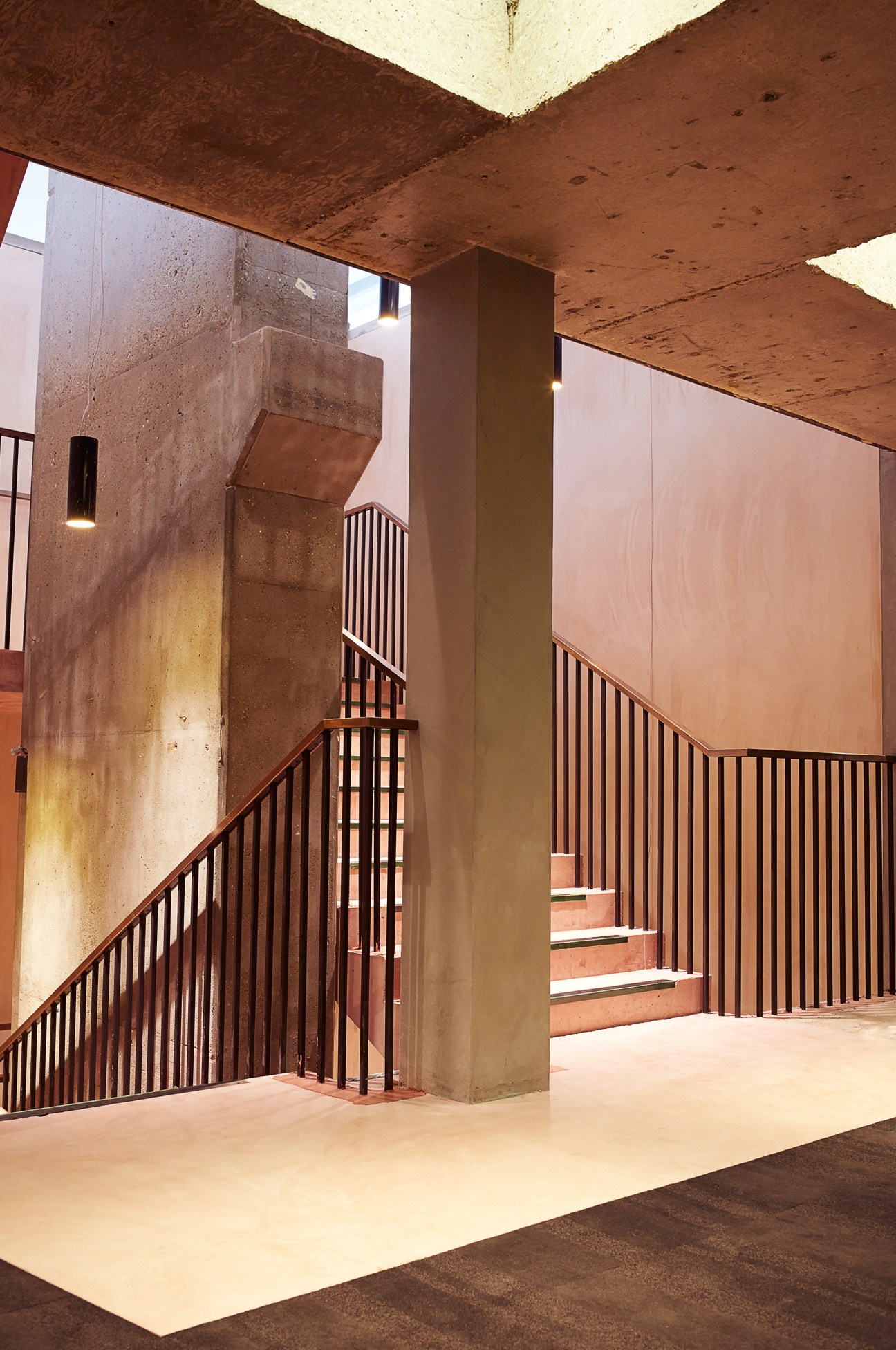 Curzon Bloomsbury's central stairwell with pink concrete walls, metal railings, and brutalist architecture.