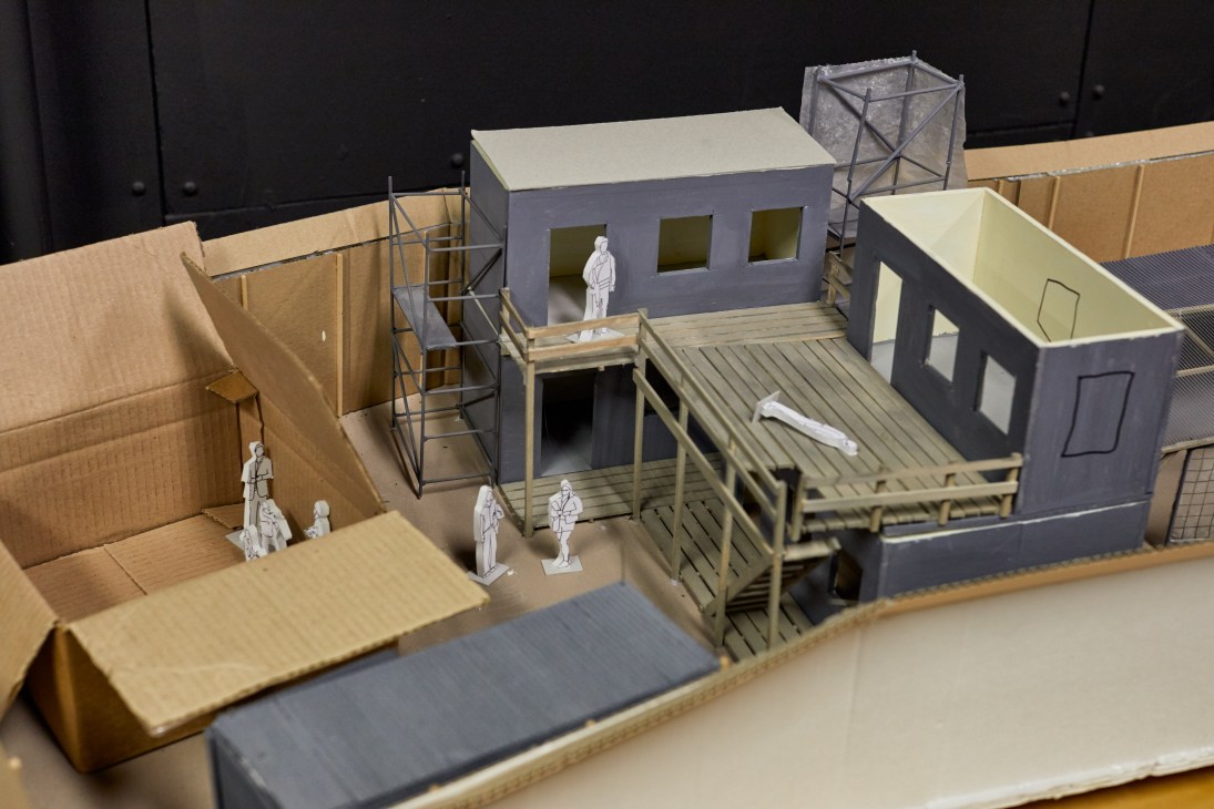 Architectural model of a subway station set with cardboard walls, platforms, and miniature figures for Below the Surface production planning.