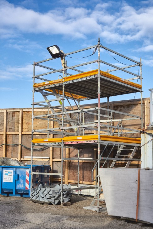 Scaffolding and yellow metal beams at a film production lot under construction in Vaerløse, Denmark.