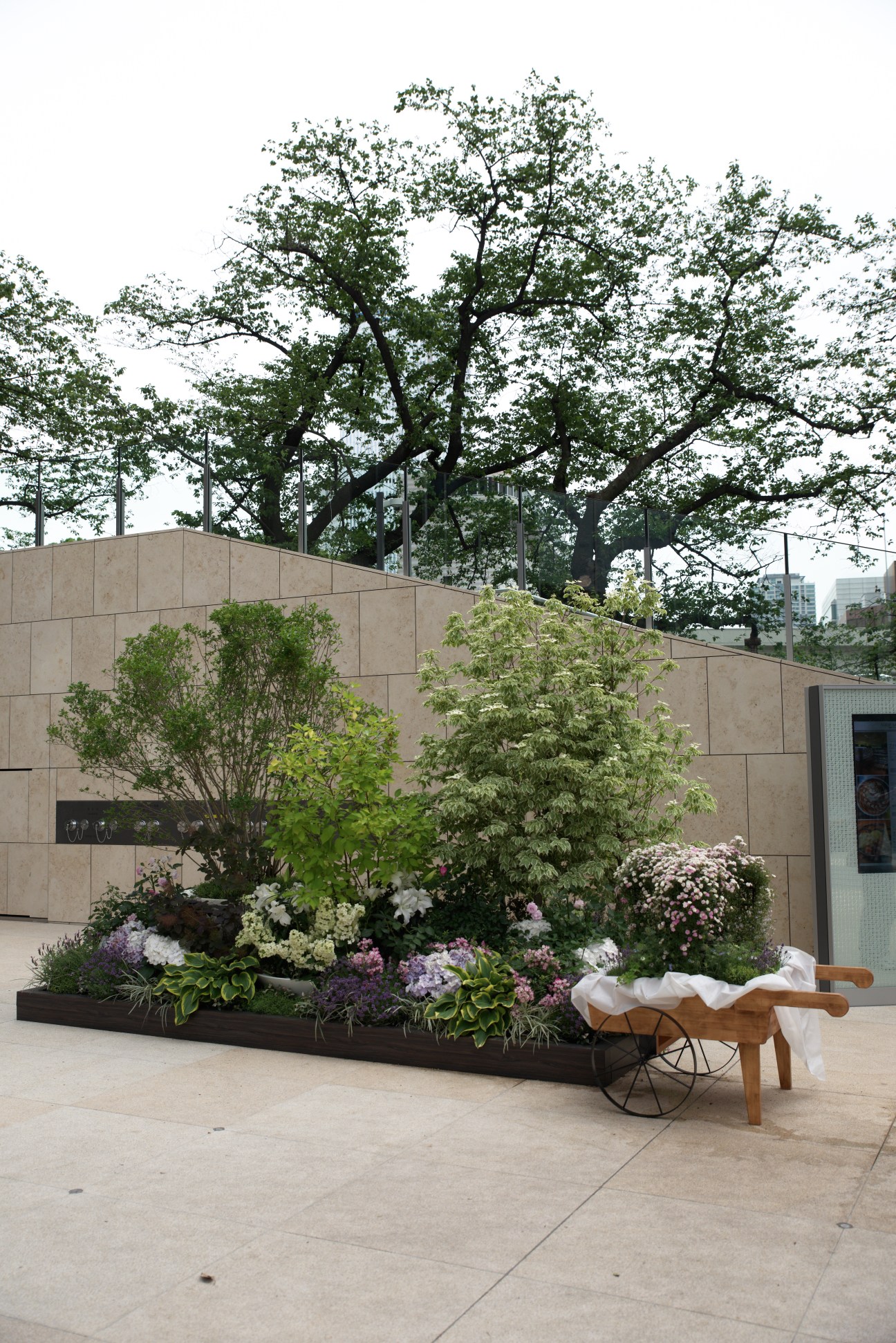 Garden area with flowering plants and large trees at Tokyo Garden Terrace Kioicho mixed-use development.