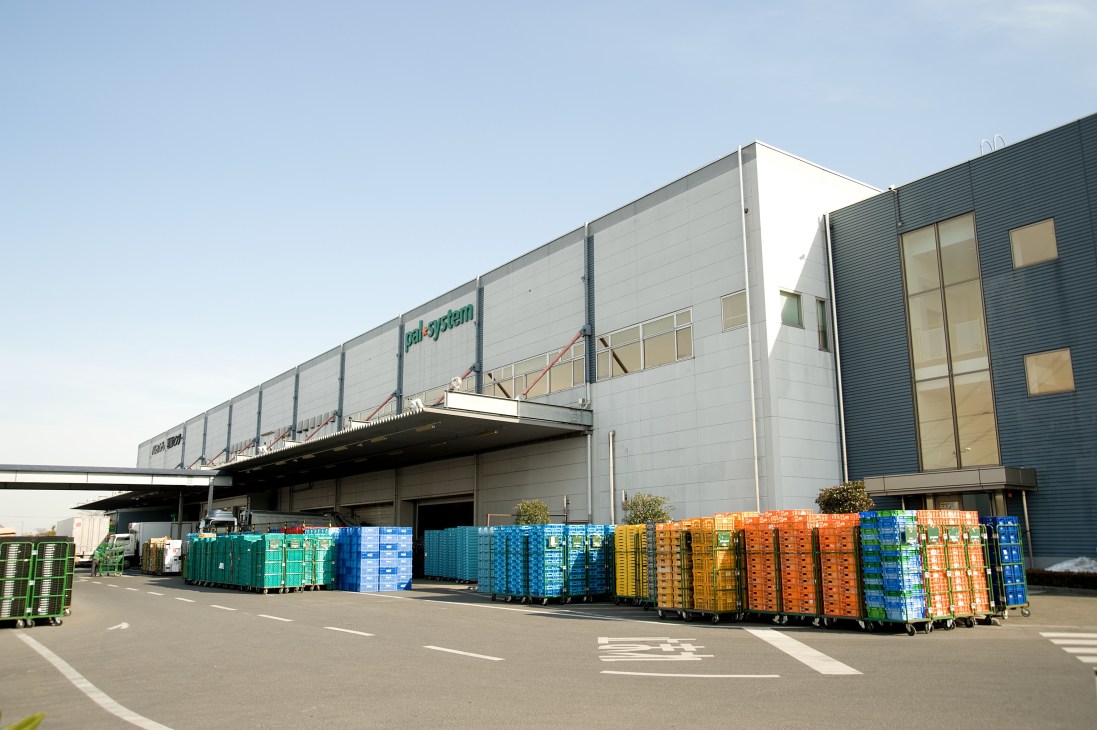 Pal System warehouse facility in Saitama with colorful plastic crates stacked outside.