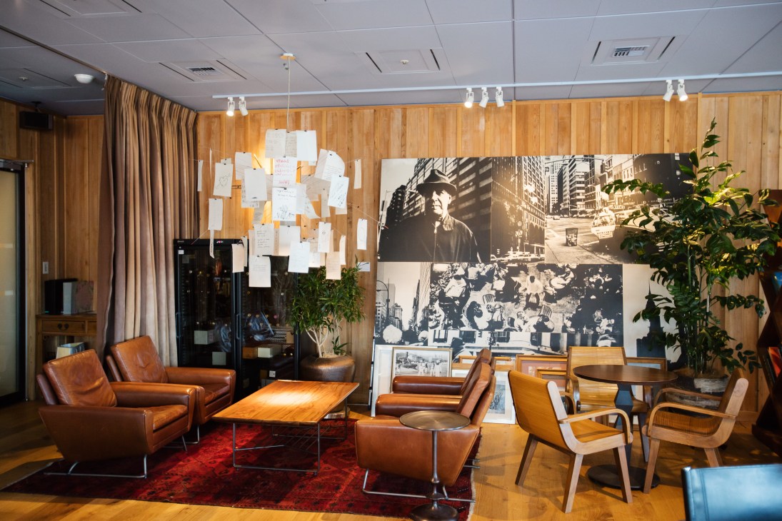 Interior of Unix Tokyo showroom with wood paneling, leather chairs, and vintage photographs on walls.