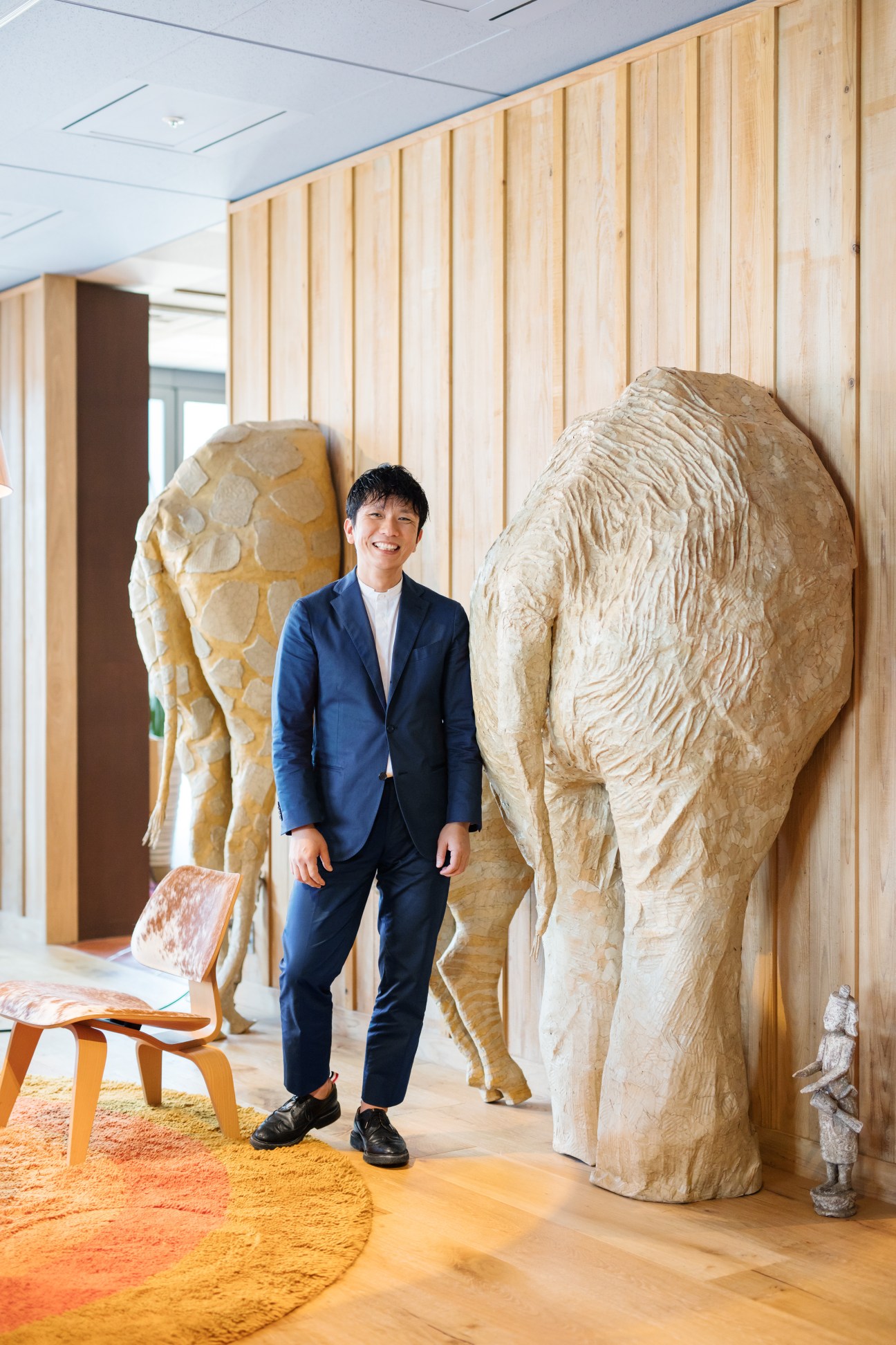 Kazuhiro Hori stands in Unix Tokyo's showroom surrounded by wooden sculptural forms.