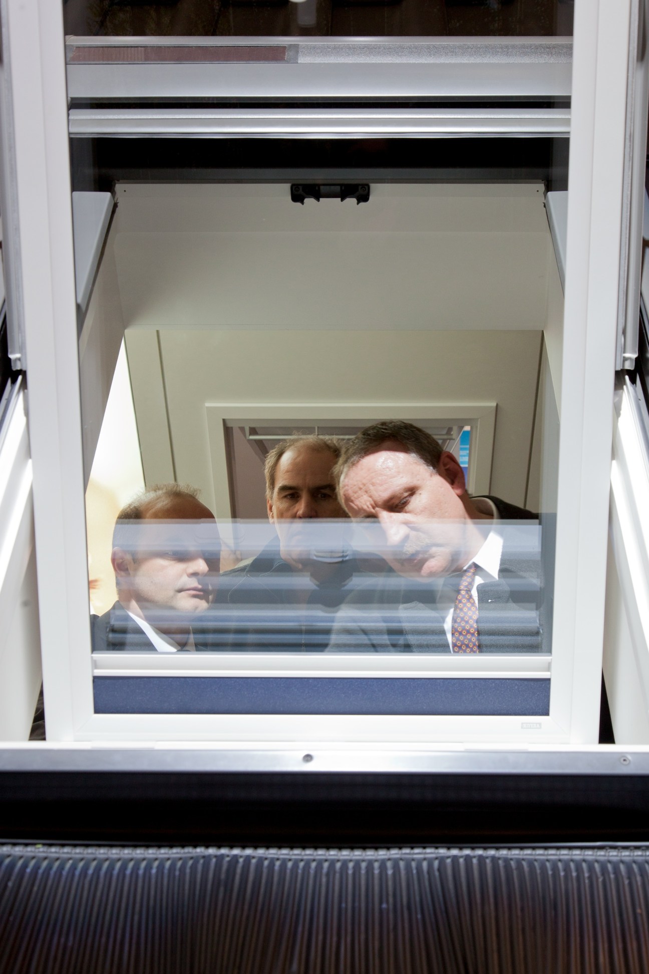Three people visible through a tilting window that opens inward at 180 degrees.