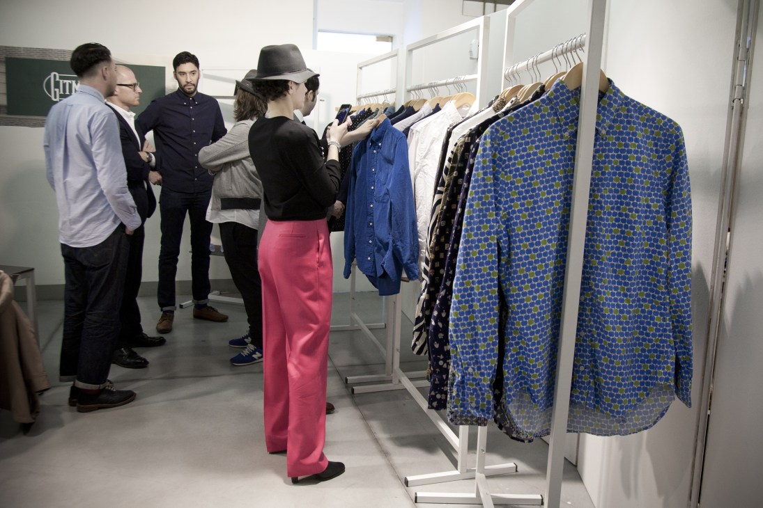 Buyers examine clothing at the Gitman Vintage booth during Pitti Uomo menswear tradeshow.