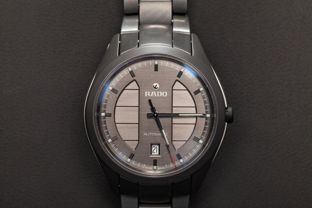 Rado HyperChrome Si3N4 Automatic watch with grey dial and metal bracelet on dark background.