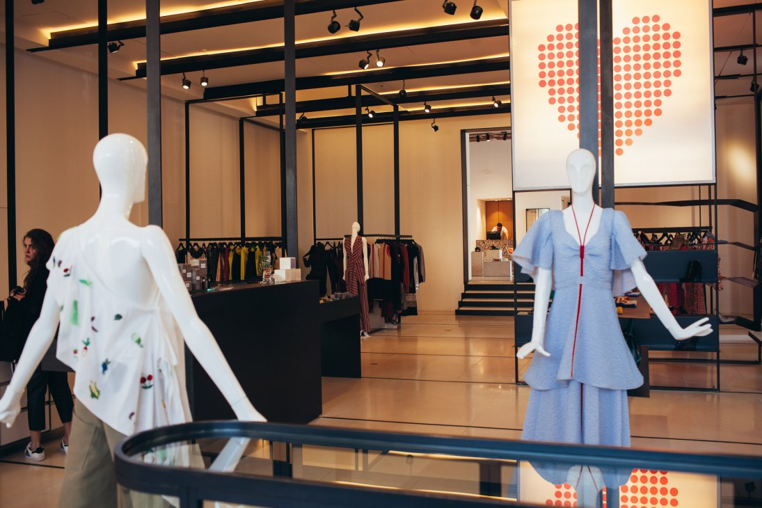 Interior of Plum Concept boutique displaying mannequins in designer clothing with modern lighting and retail displays.