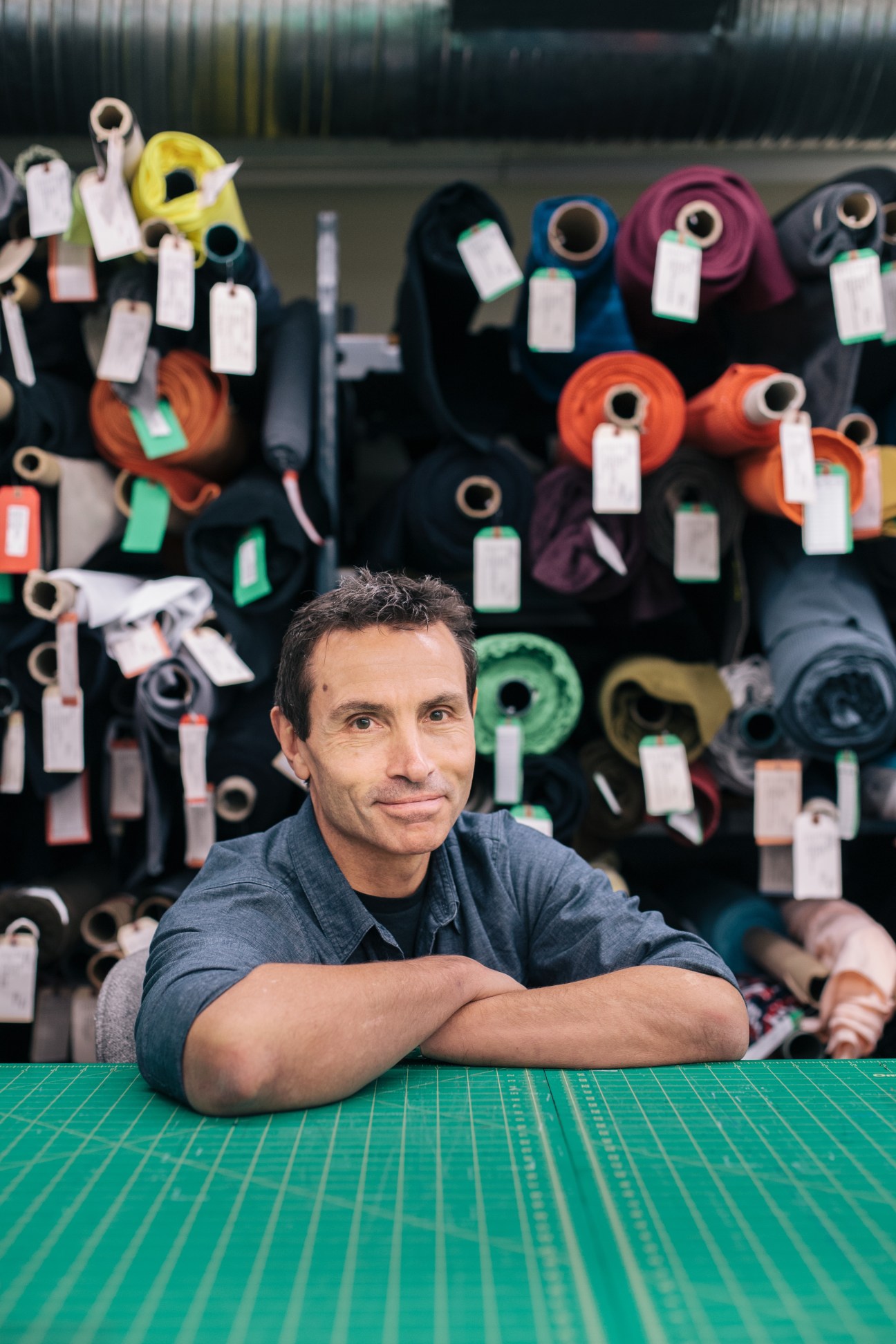 MEC president David Labistour stands in front of colorful rolled sleeping bags with price tags in the Vancouver store.