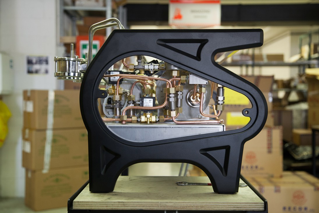 Exposed hydraulic and copper piping components of a La Marzocco espresso machine.