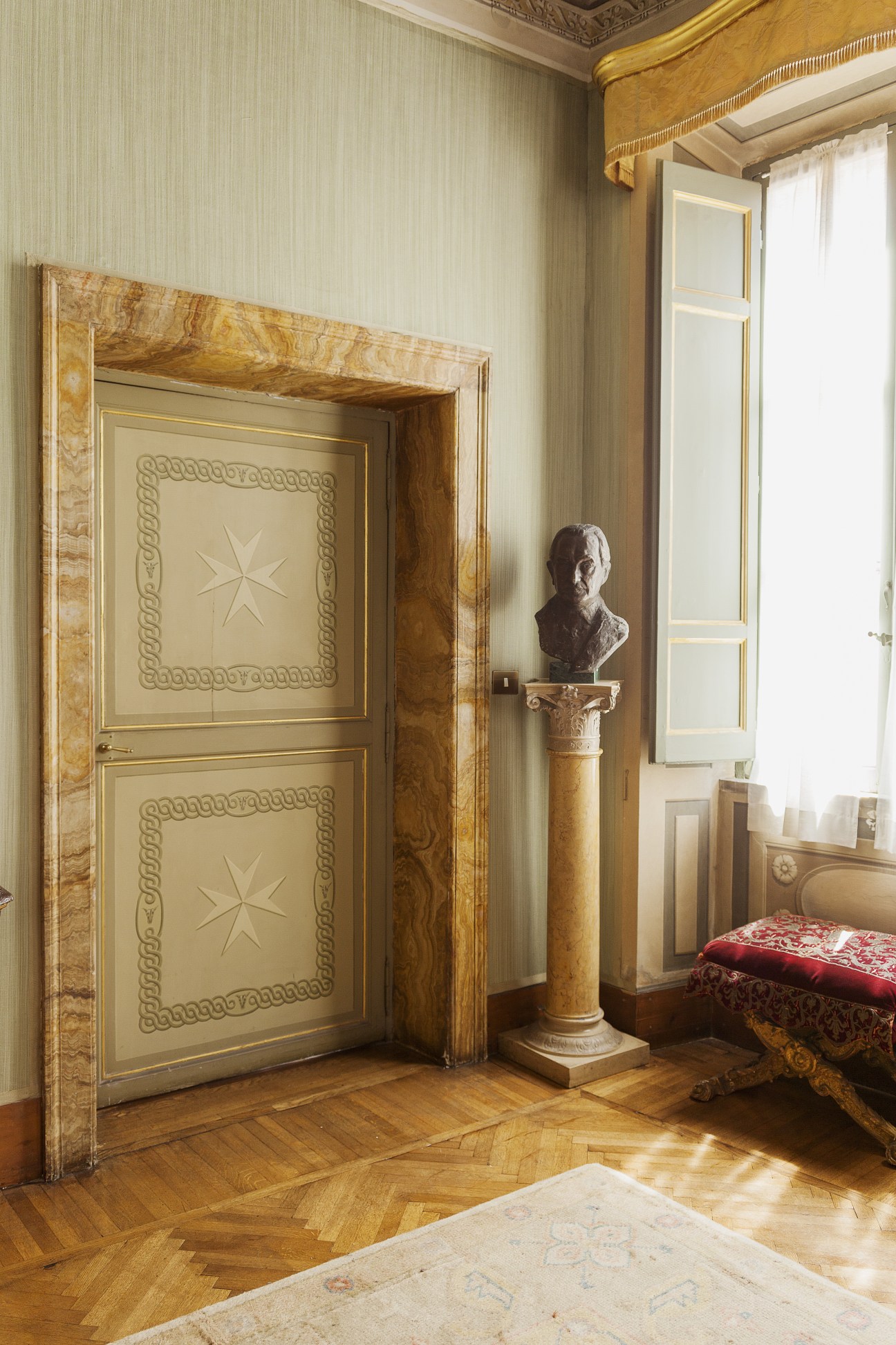 Ornate wooden door with Maltese cross relief in a classical palace state room