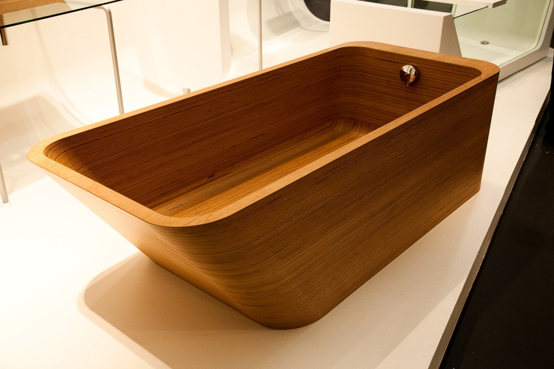 Abby bathtub by Plavis Design in teak with rounded corners and a minimalist metallic faucet.