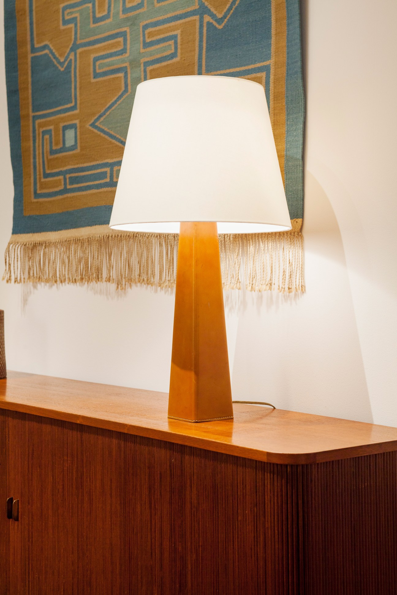 Lisa Johansson-Pape table lamp with orange base and white shade on wooden surface.