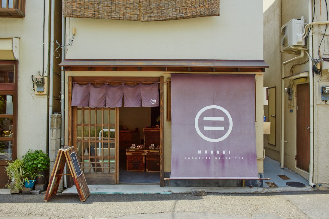 Maruni Japanese green tea shop storefront in Tokyo with purple signage and wooden entrance.