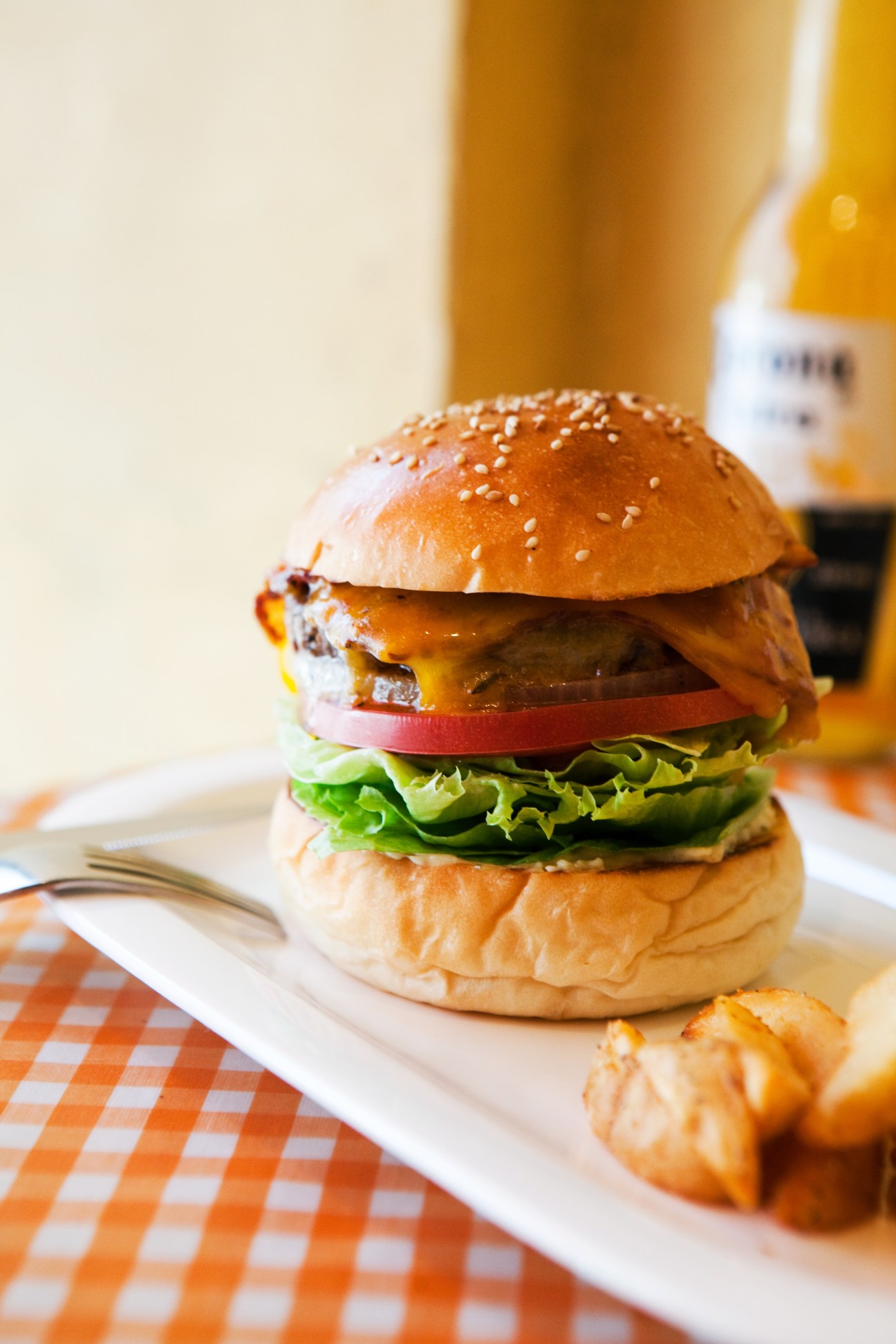 Goro's Diner burger with sesame seed bun, cheese, tomato, lettuce and chunky handcut fries.