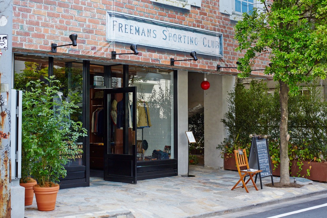 Freemans Sporting Club storefront in Tokyo with brick facade, black-framed windows and signage.