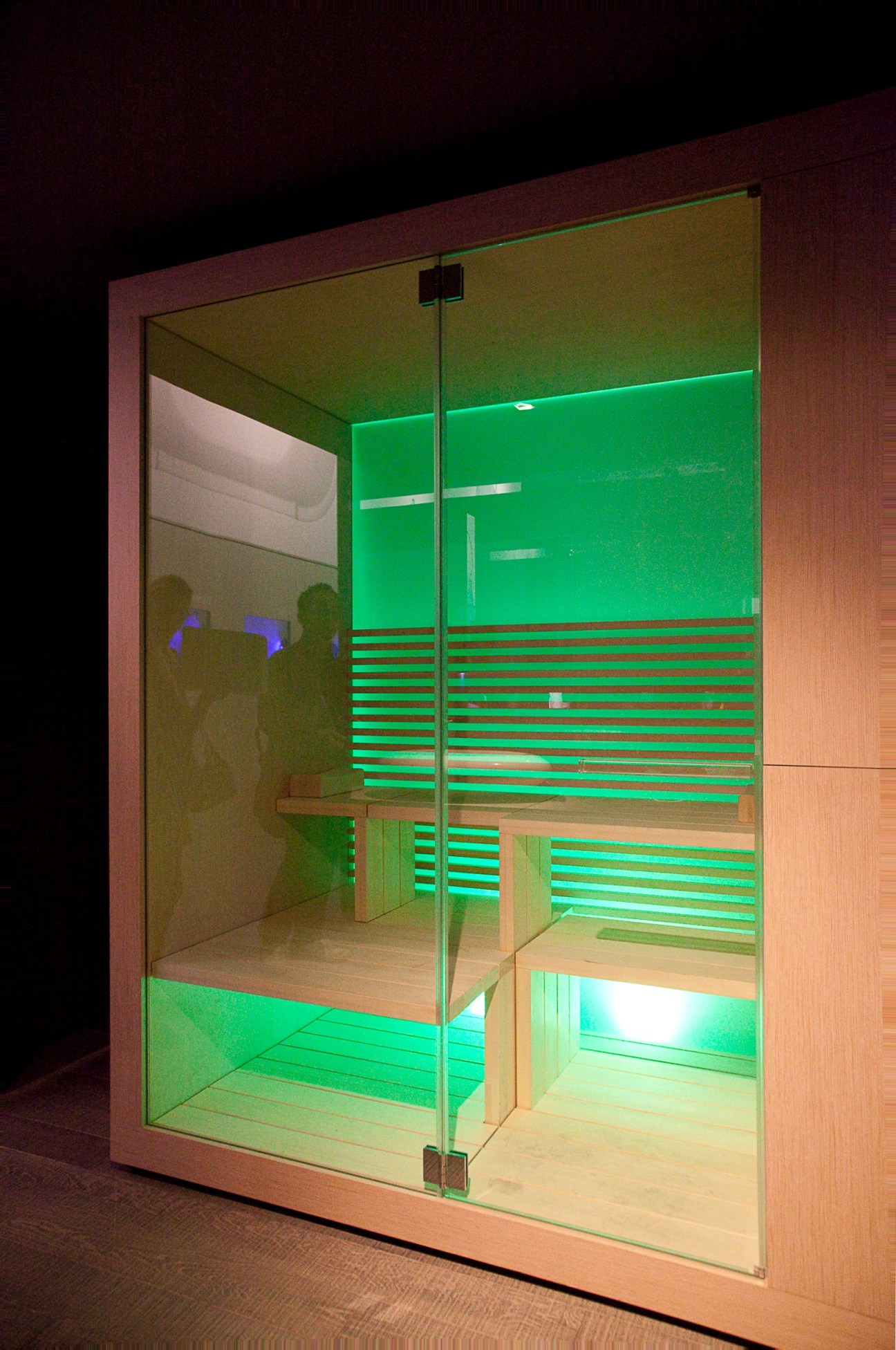 Inipi sauna by Duravit designed by EOOS, featuring wood frame with glass doors and green LED lighting inside.