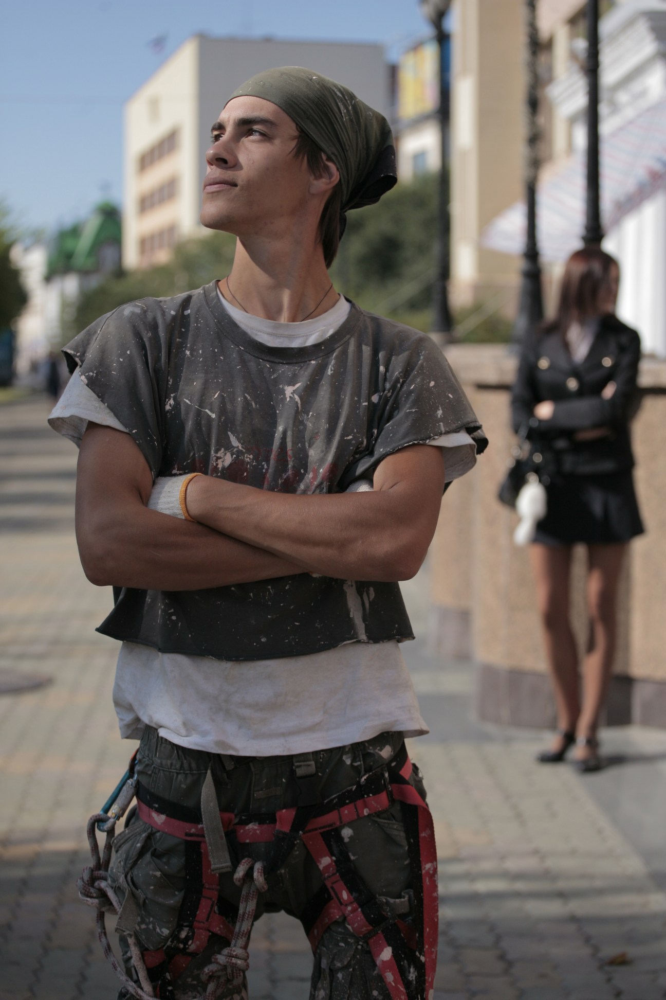 Lavrentiy Nikitrin, a commercial painter, stands in a residential street in Khabarovsk wearing work clothes with paint stains.