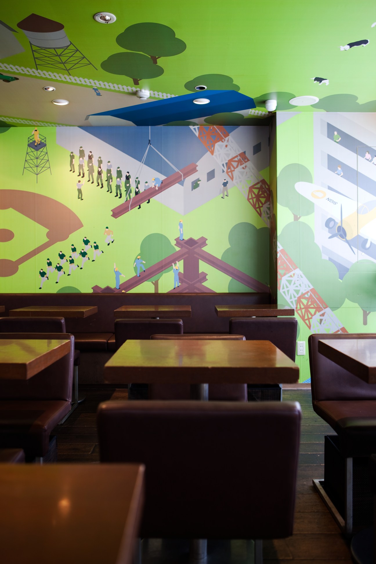 Sign Café interior in Tokyo with colorful illustrated wall mural and dark furniture.