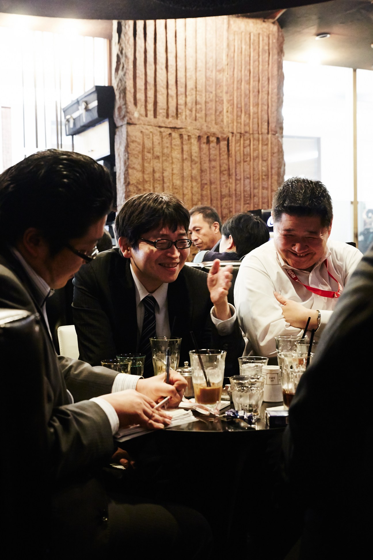 Business professionals in suits having a meeting at Stone café in Tokyo with coffee and water glasses on the table.