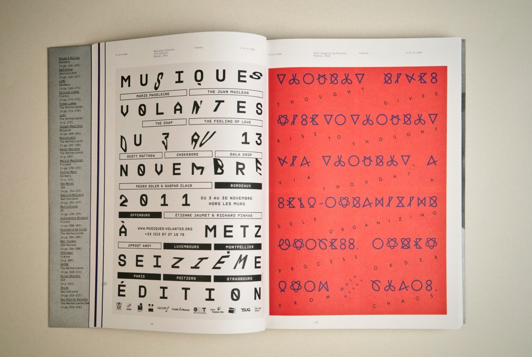 Open book showing typography design with black text on white page and red page with encoded symbols.