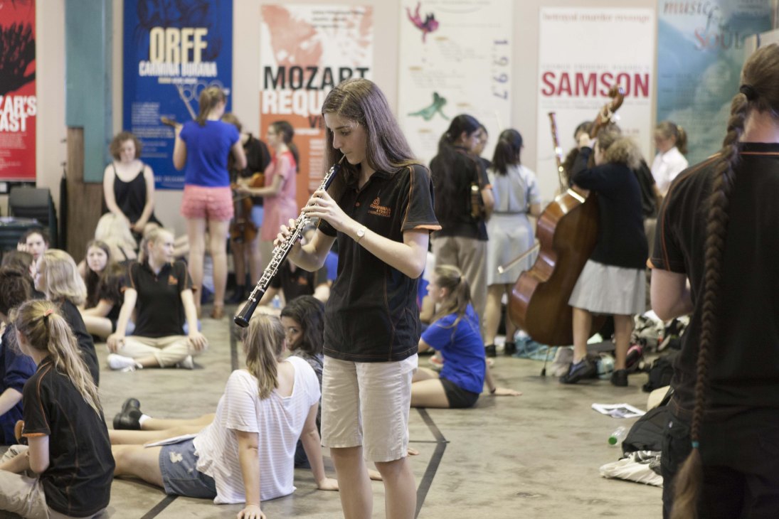 Young musician plays flute during a break at Gondwana Choirs rehearsal in Sydney.