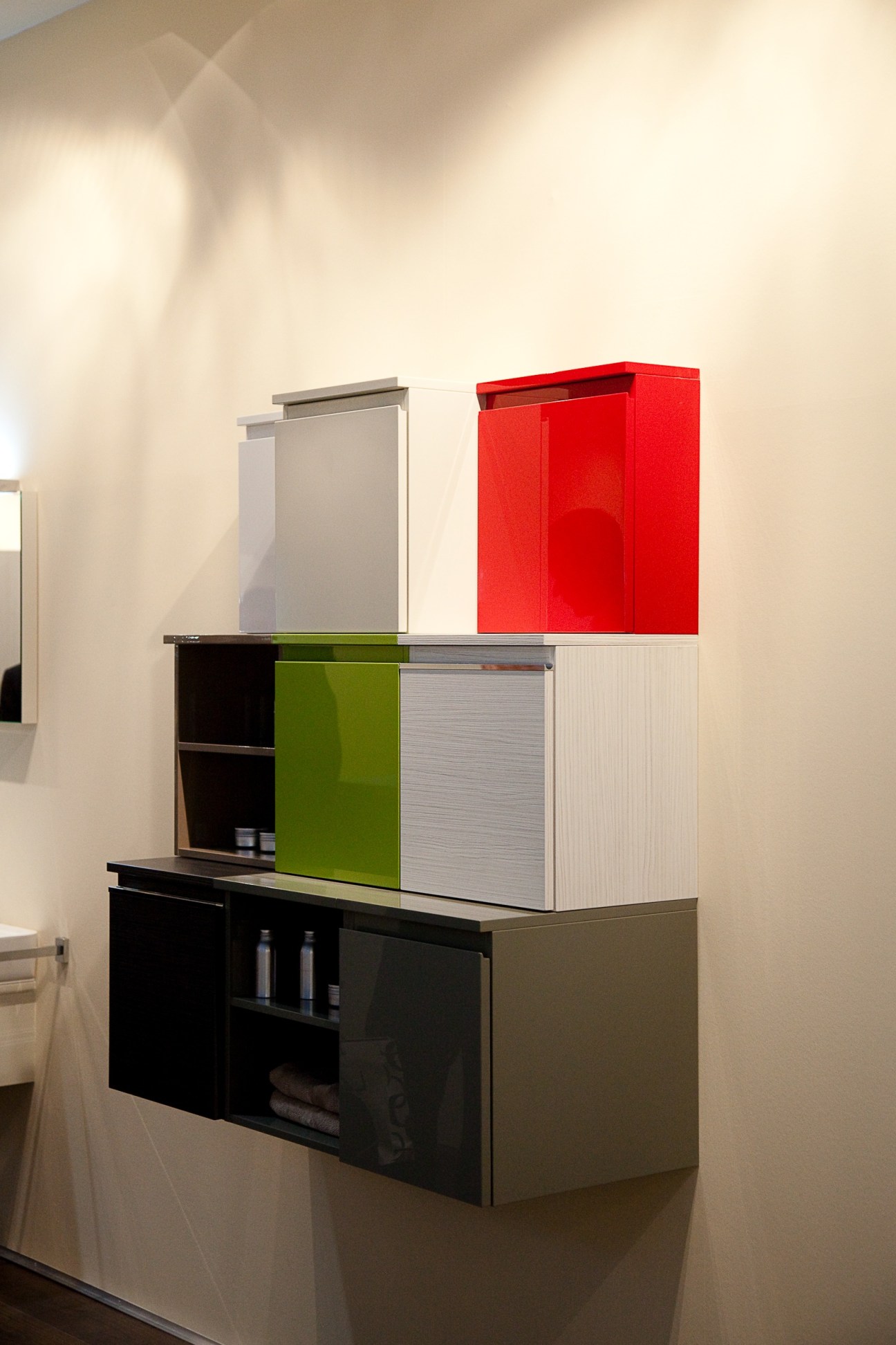 Burgbad modular bathroom storage unit with stacked coloured cabinets in red, green, white and black.