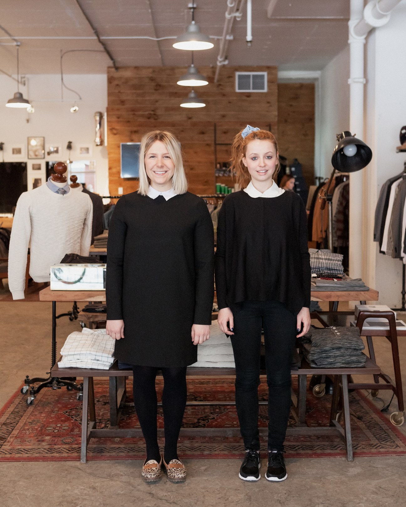 Sophie Desbiens and colleague stand in Frank & Oak retail space with clothing displays and pendant lights.