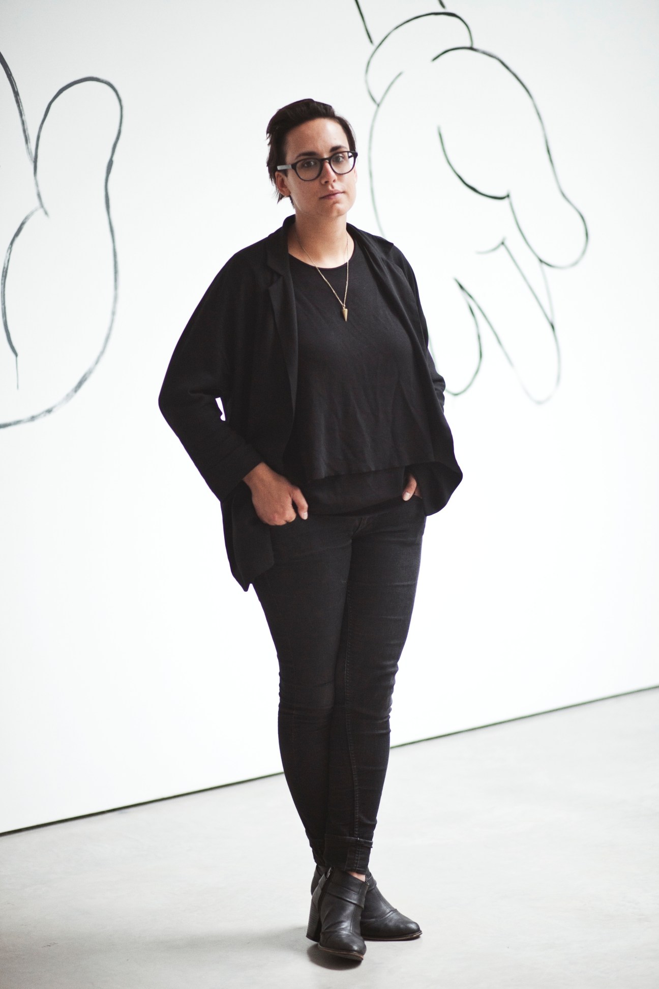 Hana Noorali, art fair manager at Lisson Gallery, standing in front of abstract line drawings on a white wall.