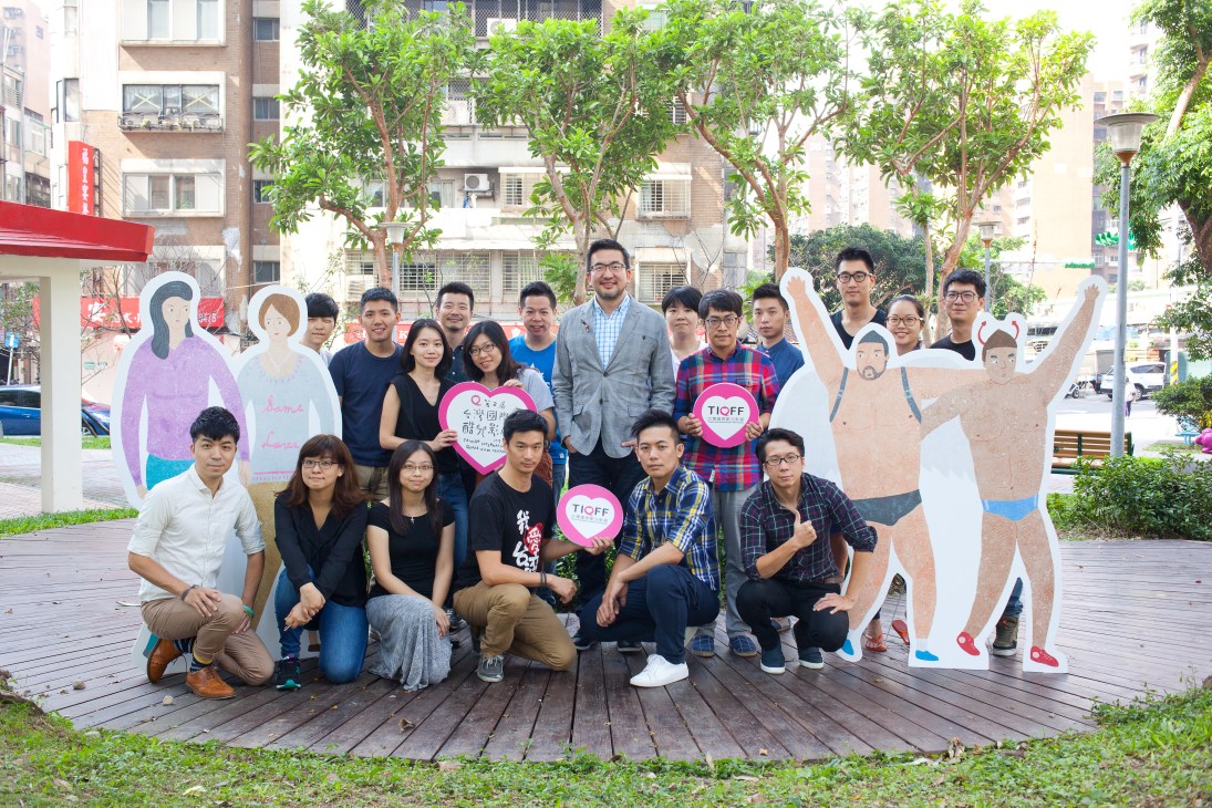 Jay Lin and staff members of Taiwan International Queer Film Festival posing in Taipei's Da'an district with cutout figures and TIQFF signs.