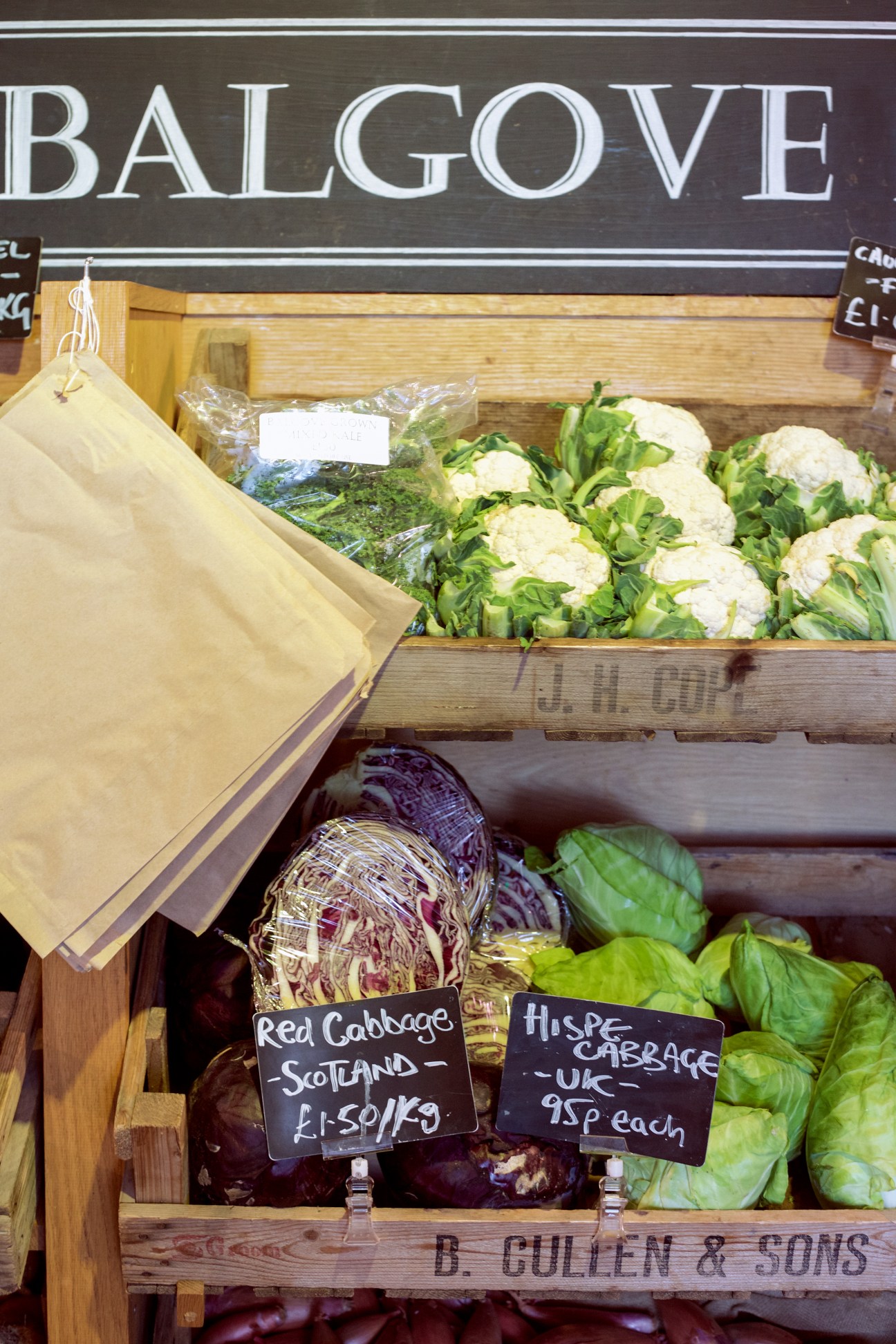 Balgove Larder produce display with fresh Scottish and UK vegetables including cauliflower, red cabbage and hispi cabbage with price labels.