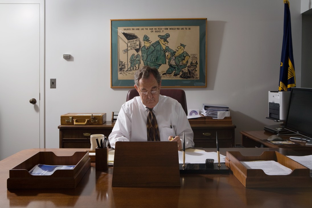 Mel Russell, boss of the American Forces Radio and Television Service, works at his desk in his office.