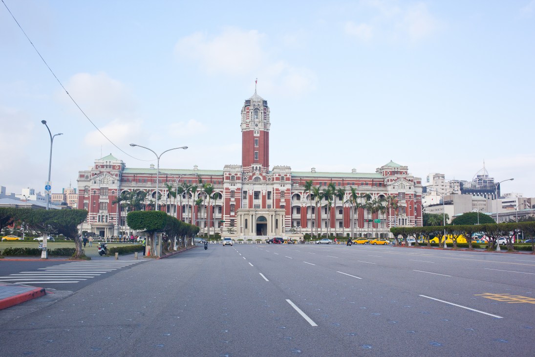 The red-brick Presidential Office Building in Taipei with its distinctive tower, viewed across a wide plaza.