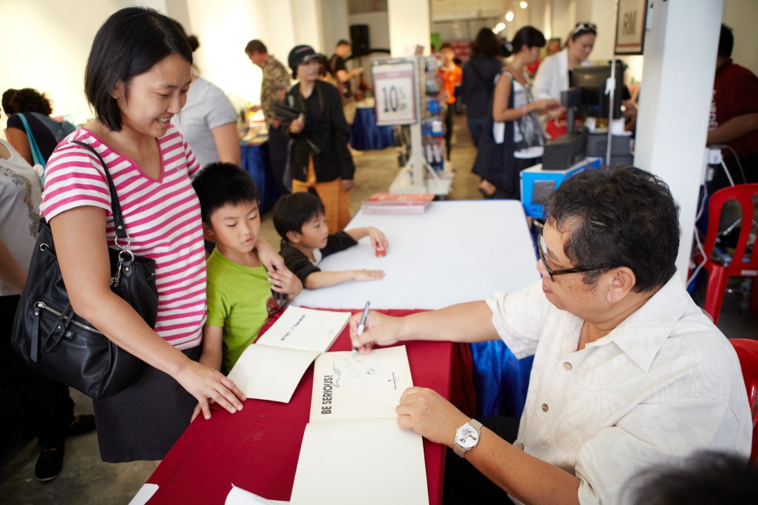 Cartoonist Lat signs books for readers at the George Town Literary Festival in Penang.