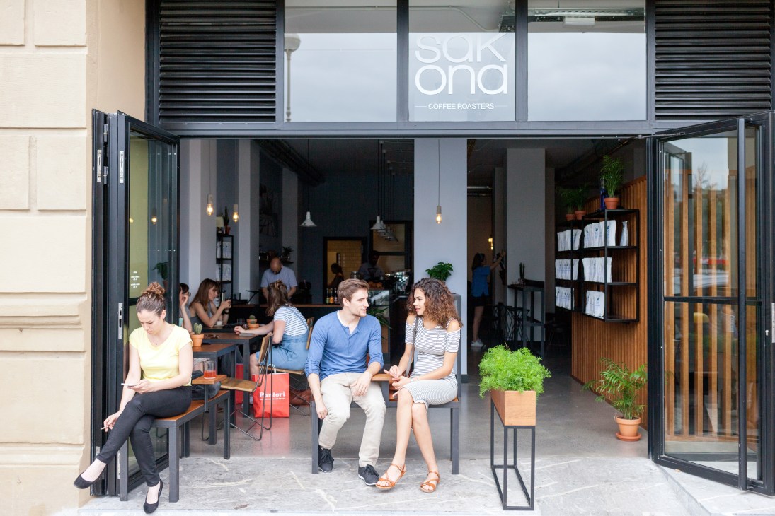 Sakona Coffee Roasters storefront in San Sebastián with customers seated outside on a sunny day.
