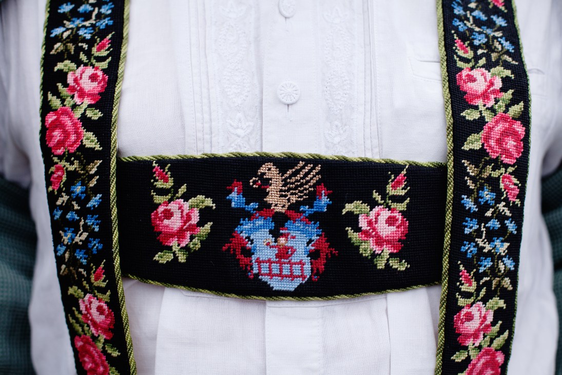 Embroidered Bavarian braces with floral and coat-of-arms designs in red, blue, and gold on black.