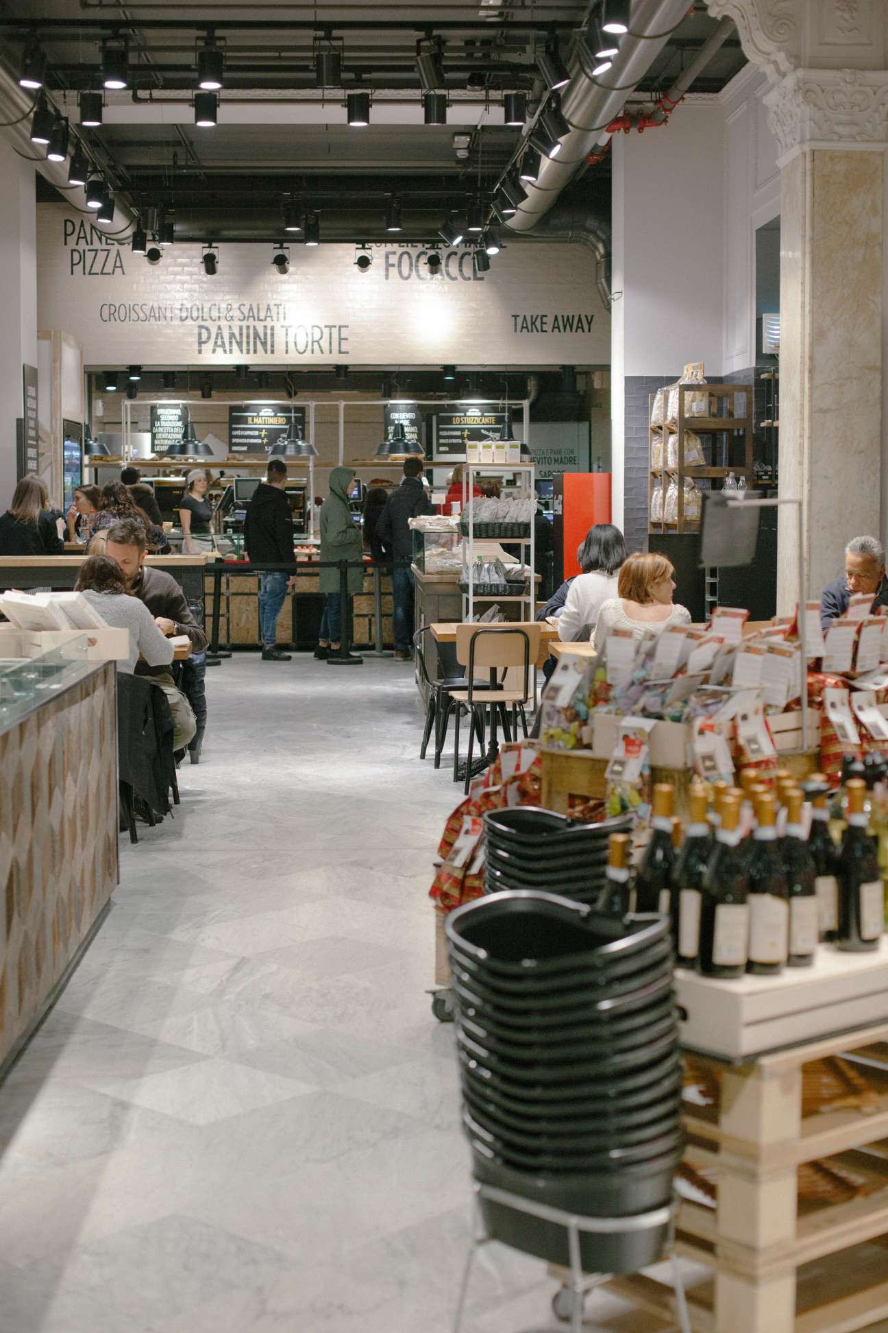 Interior of Il Mercato del Duomo Autogrill Bistrot showing counter service area with menu signage and retail shelves.