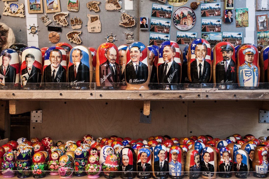 Russian nesting dolls displayed in a tourist shop showing political figures and traditional designs.