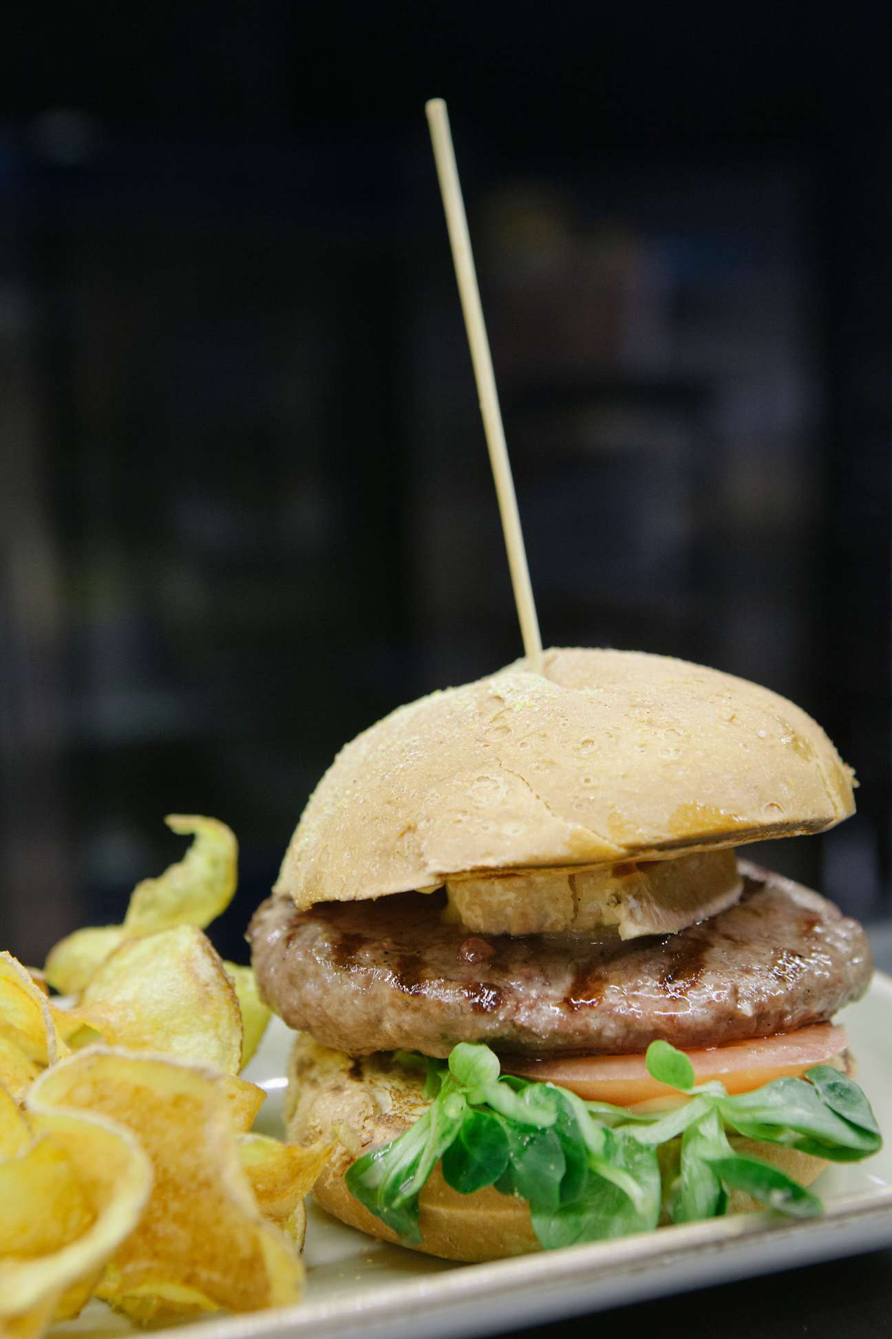 Bistrot hamburger with melted cheese, tomato and greens, served with crispy golden fries on the side.