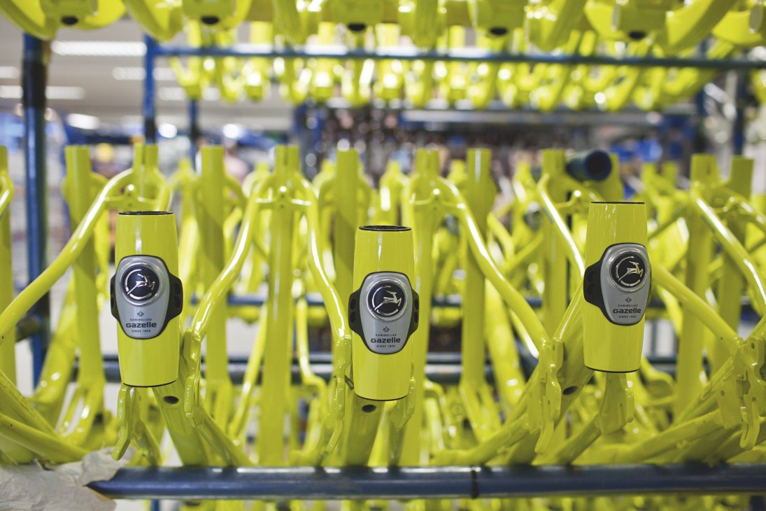 Bright yellow Gazelle bicycle frames on an assembly line in the factory.